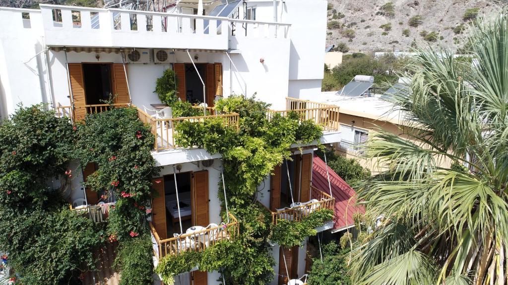an apartment building with plants on its balconies at Lissos Rooms Sougia in Sougia