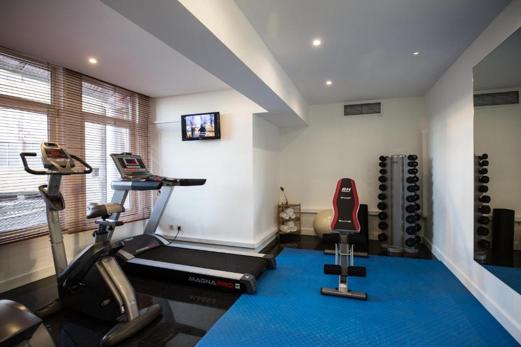 a gym with two exercise bikes and a treadmill at Legendary Porto Hotel in Porto