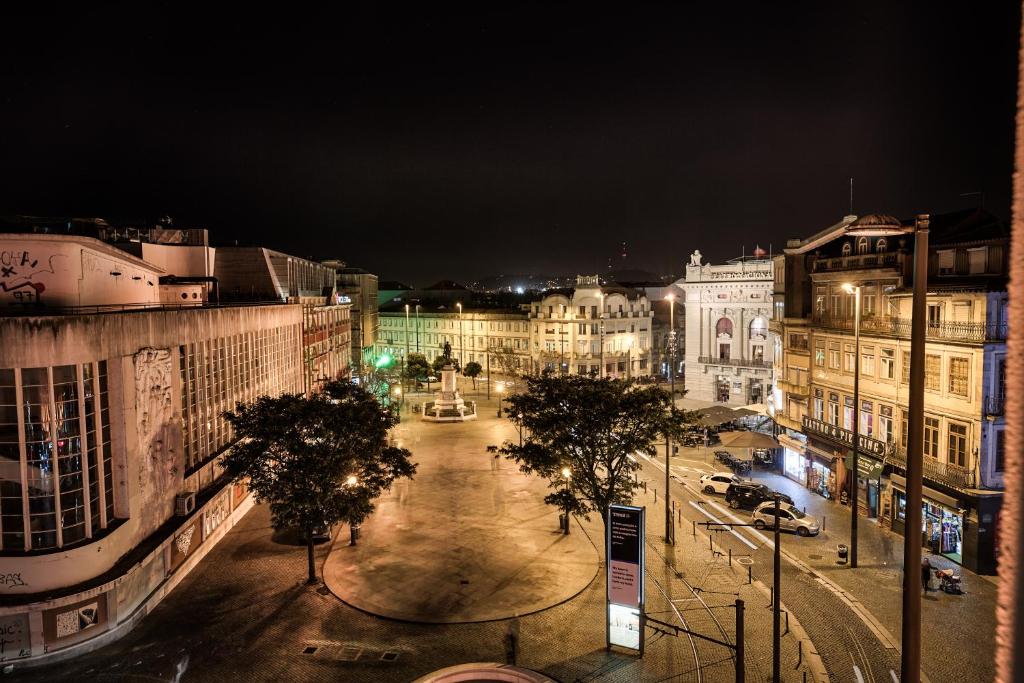 a city street at night with buildings and trees at Legendary Porto Hotel in Porto