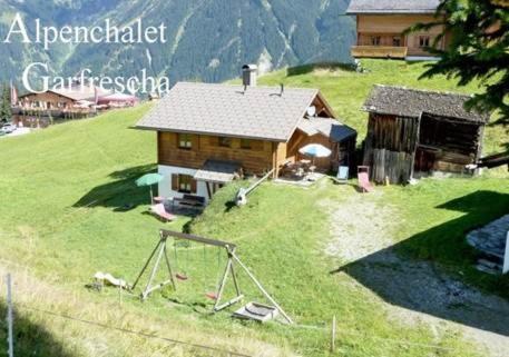 ザンクト・ガレンキルヒにあるAlpenchalet Garfreschaの緑の丘の上の小屋