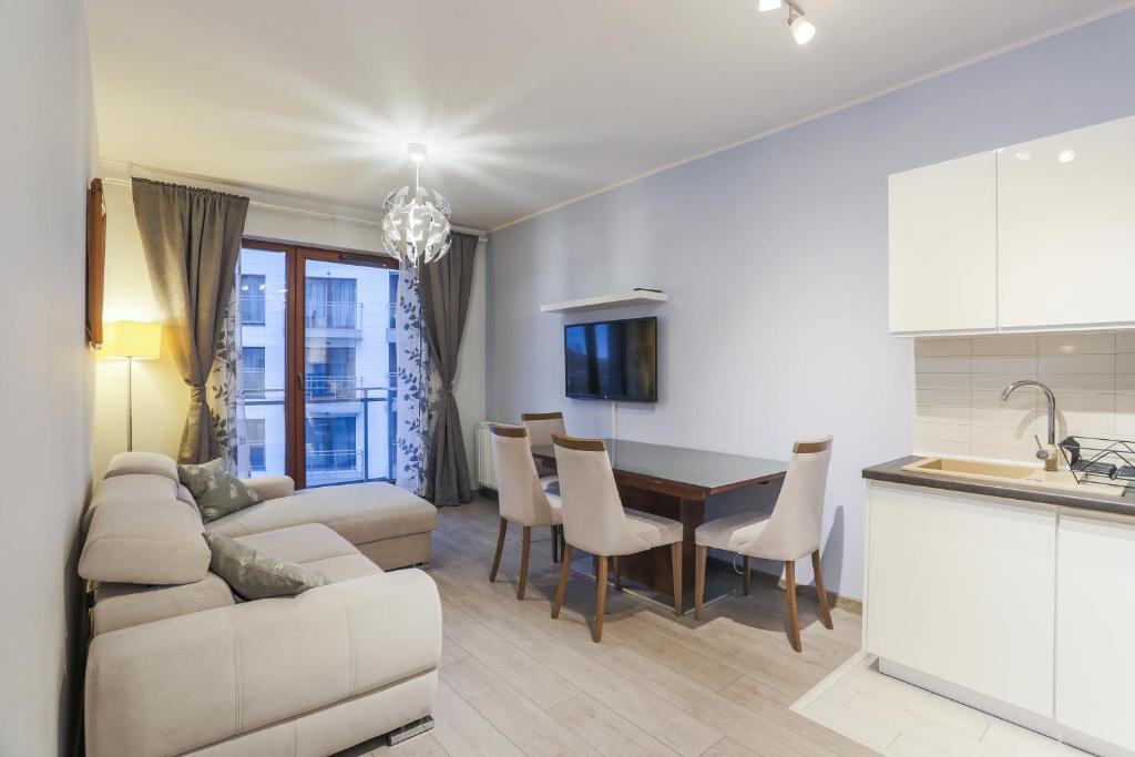 グダニスクにあるApartament z widokiem na rzekę Gdańsk Stare Miastoのソファとテーブルのあるキッチンとリビングルーム