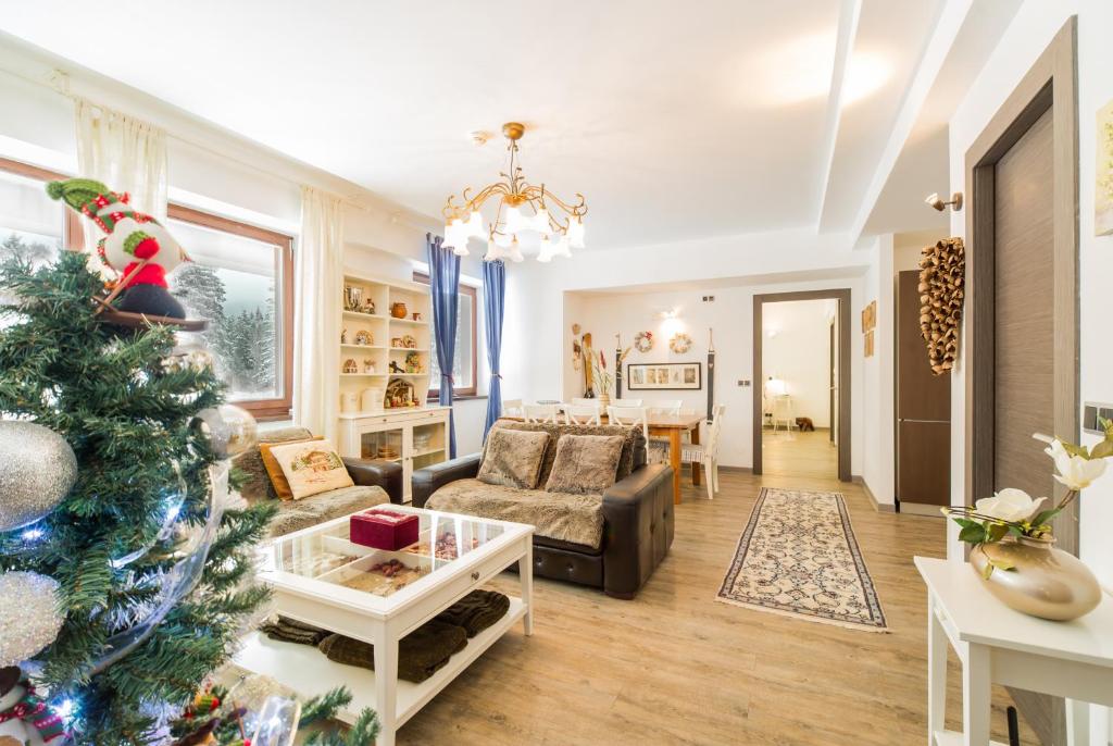 a living room with a christmas tree and a couch at Charming 3-Bedroom Apartment in Poiana Brasov