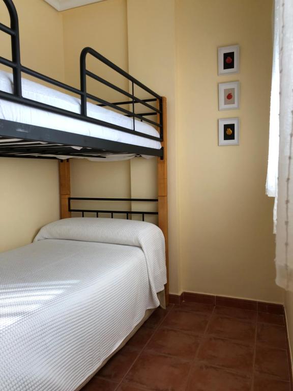 2 Etagenbetten in einem Zimmer mit Fliesenboden in der Unterkunft Playa y tranquilidad en El Portil in El Portil