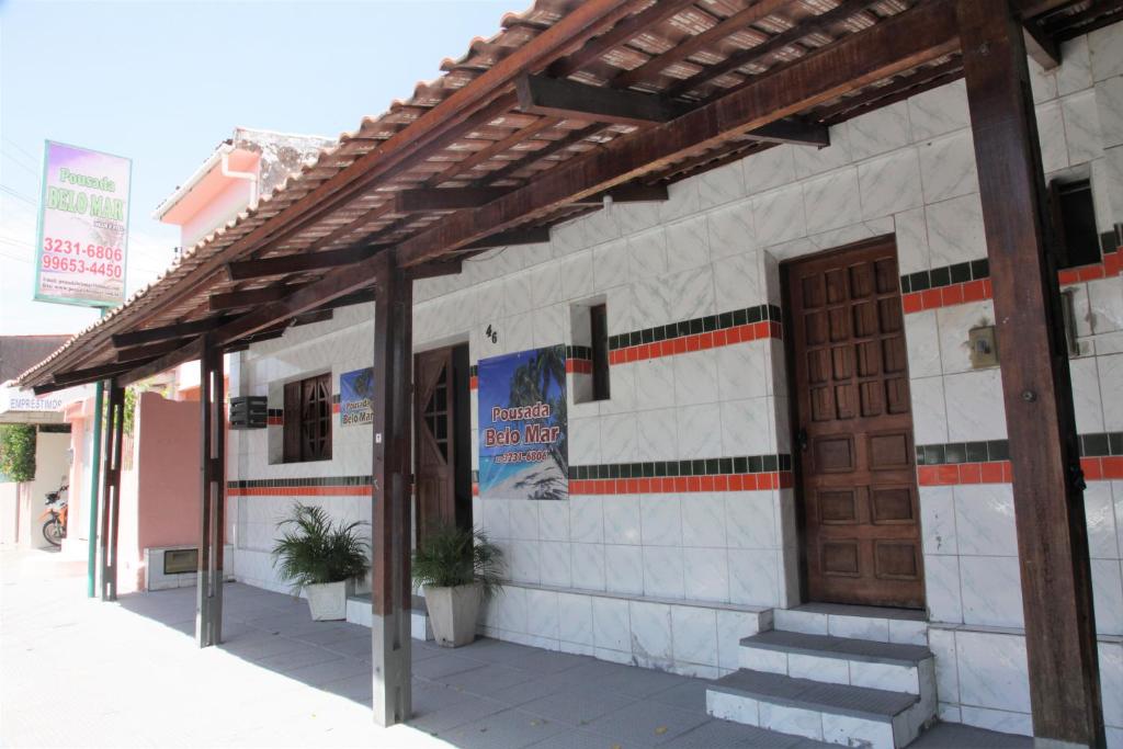 a building with a door and stairs on a street at Pousada Belo Mar in Maceió