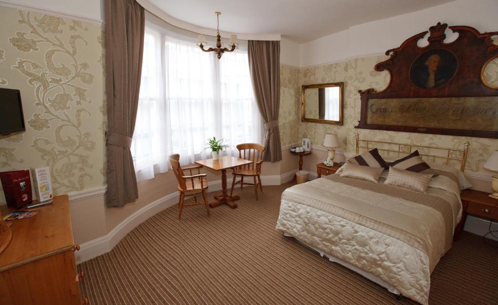 a bedroom with a bed and a table and a window at The Market Inn in Brighton & Hove