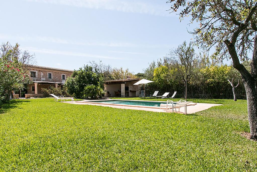 une cour avec une piscine et une maison dans l'établissement Country House Cadernera, à Búger