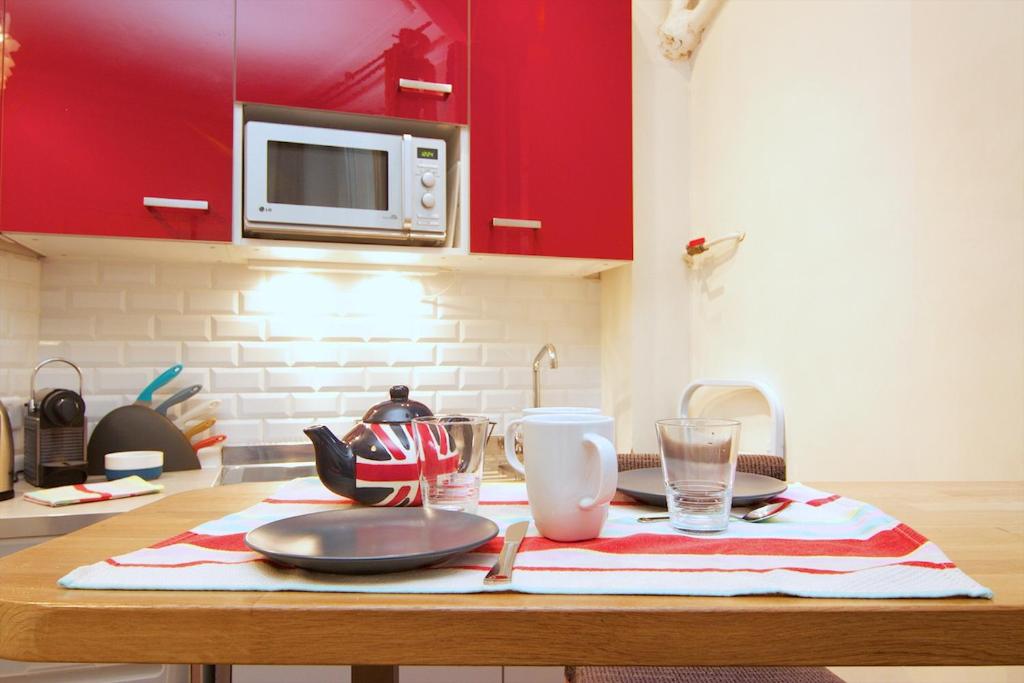 a kitchen with a table with a plate and a microwave at Studio Saint Sulpice in Paris