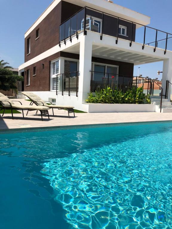 una casa con piscina frente a una casa en Villa Mondrian, en Puerto Marino