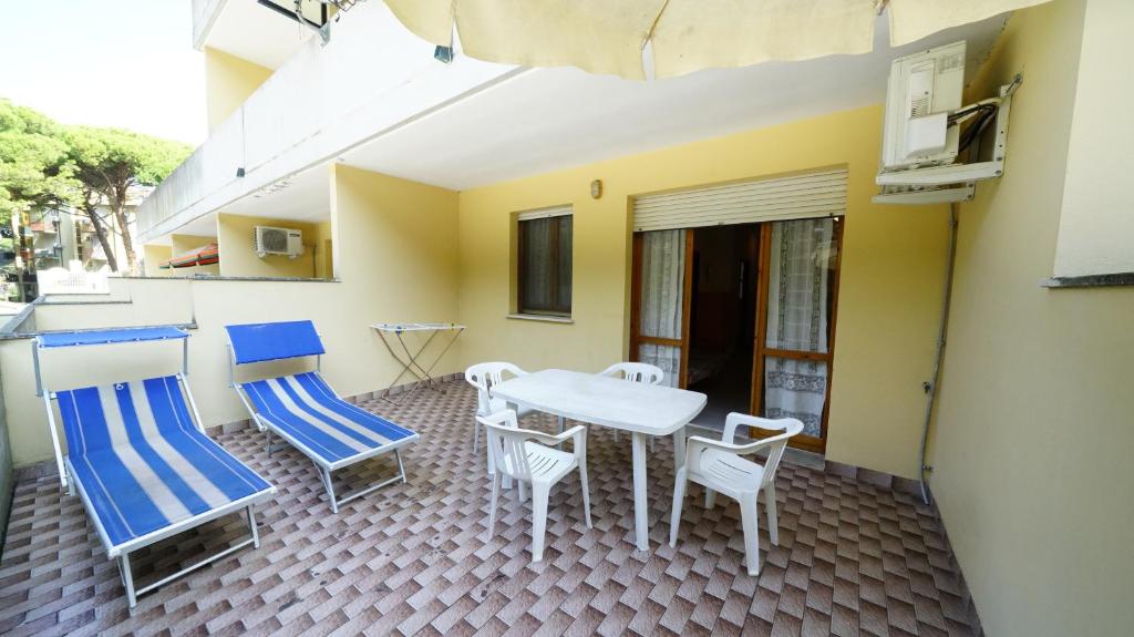 a patio with a table and chairs on a balcony at Residenza Emilia in Lido degli Estensi