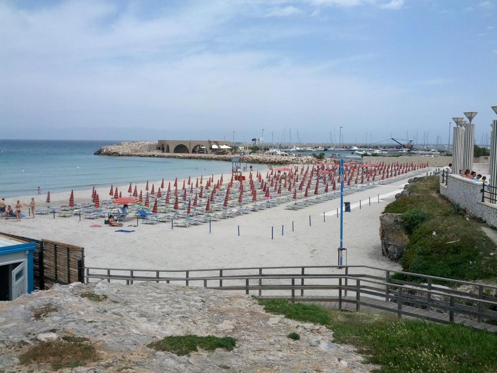 a beach with chairs and umbrellas and the ocean at Villetta Rosetta by RENTHOUSESALENTO- a 100 m dal mare in San Foca