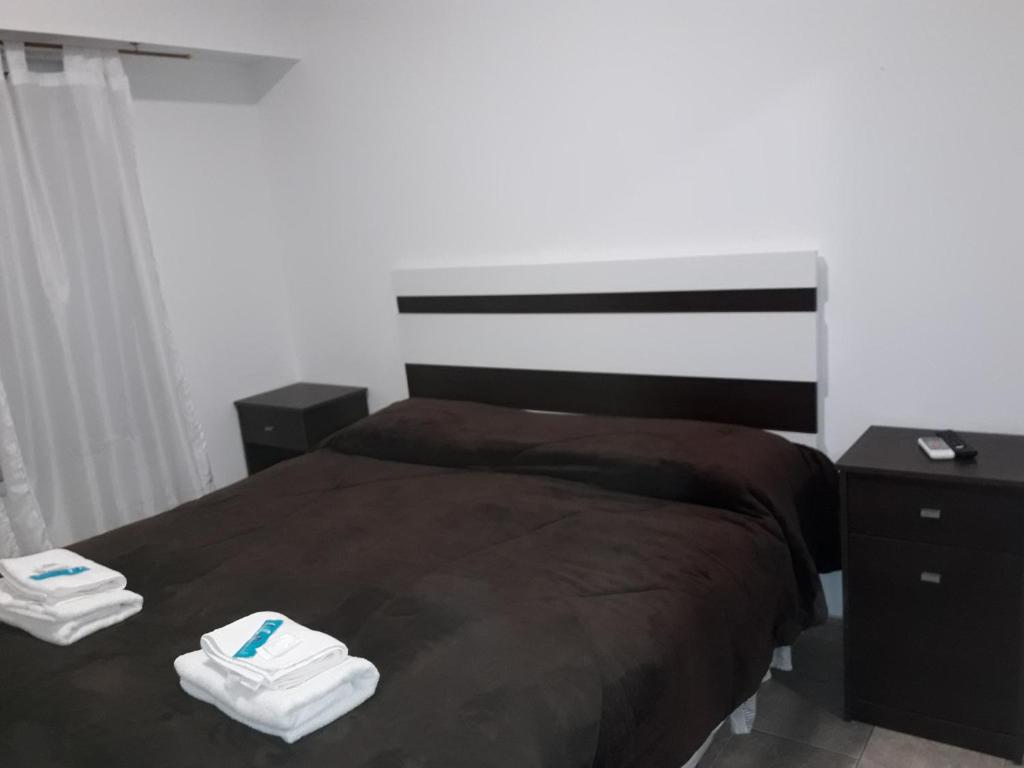a bedroom with a bed with two towels on it at Apartamento céntrico 19 de Mayo 2 con cochera in Bahía Blanca