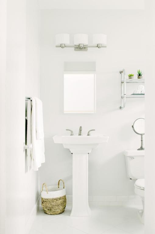 ロサンゼルスにあるベイサイド ホテルの洗面台とトイレを備えた白いバスルーム