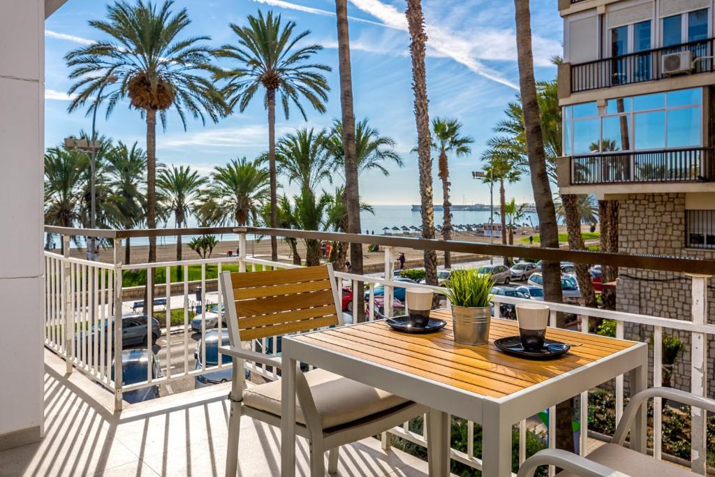 balkon ze stołem, krzesłami i palmami w obiekcie Smart Malagueta Seaview w Maladze