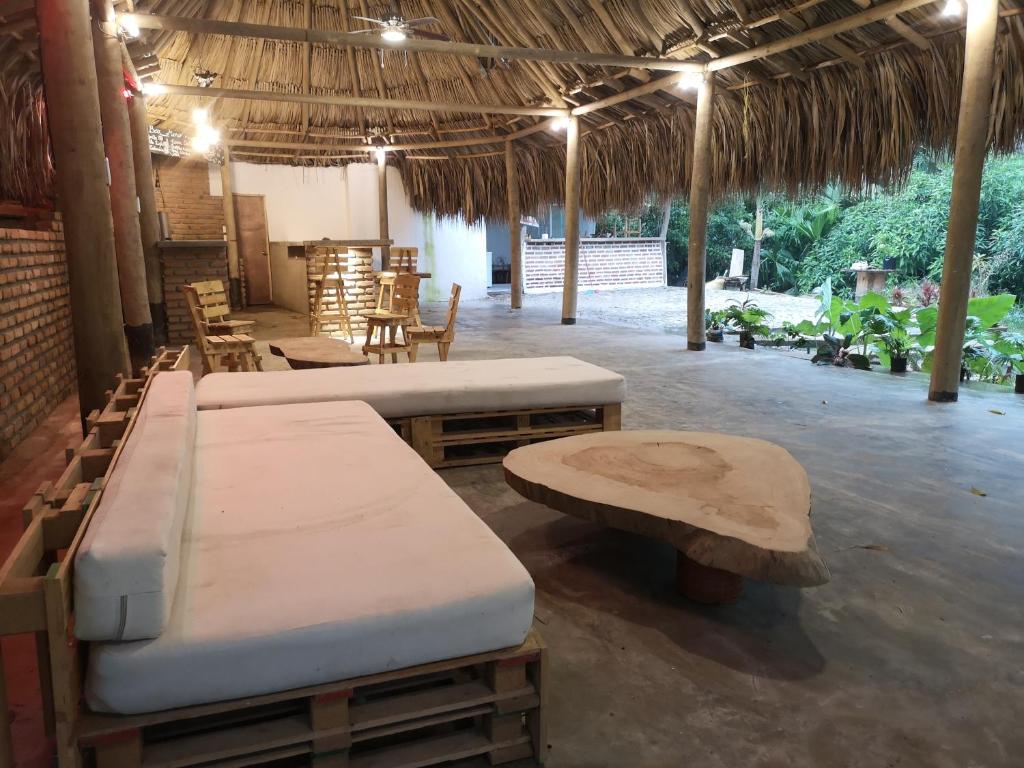 una stanza con due letti, un tavolo e delle sedie di Hostal Mama Tayrona a Santa Marta