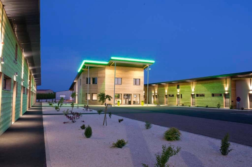 a large building with a courtyard in front of it at Bio Motel in Semoutiers