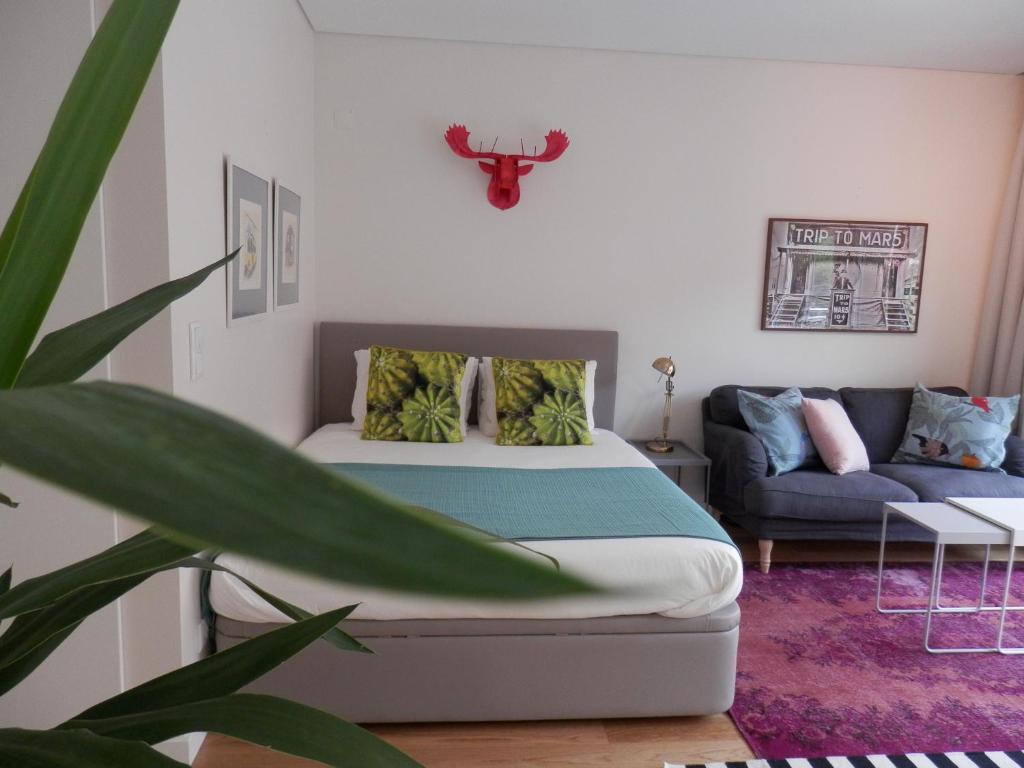 una camera da letto con un letto e un divano di Ripple - Modern Condo with pool, aircon, parking a Lisbona