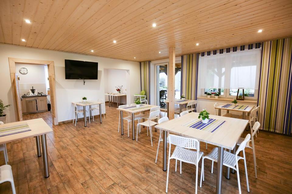 a room with tables and chairs and a flat screen tv at Willa Plażowa in Mielenko