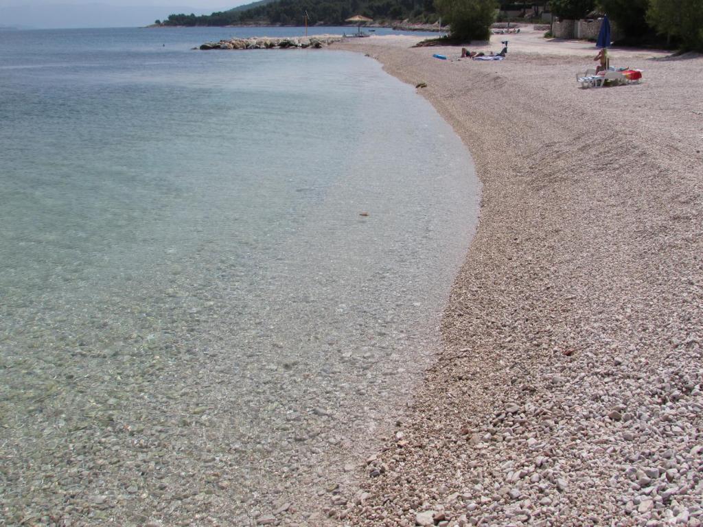 una playa con una costa rocosa y el agua en Bonacic Palace, en Slatine