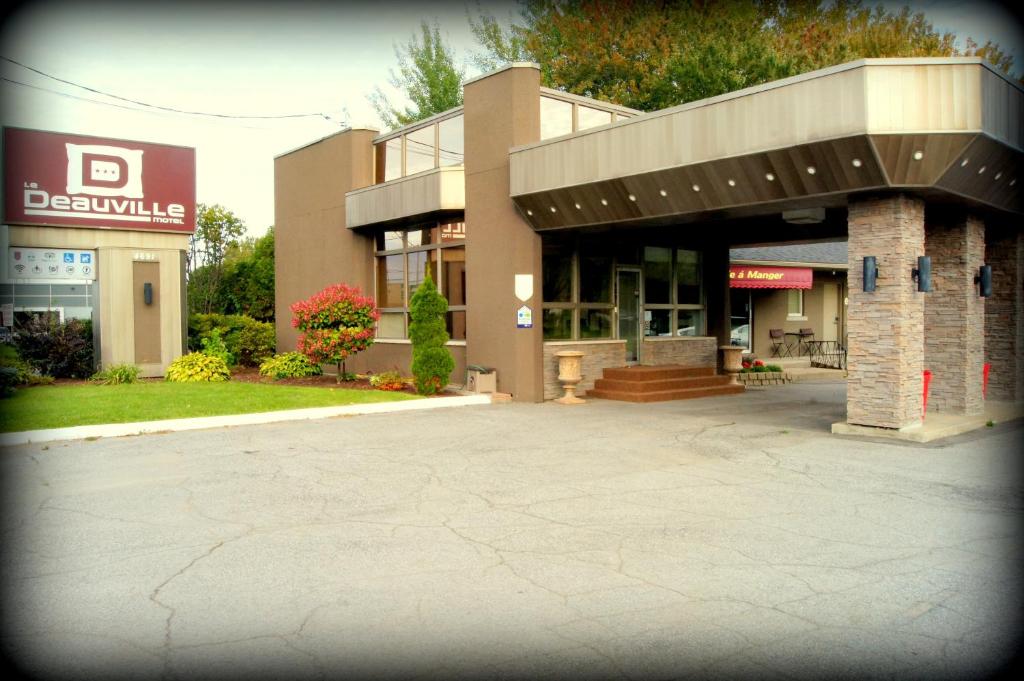 a parking lot in front of a building at Le Deauville Motel in Trois-Rivières