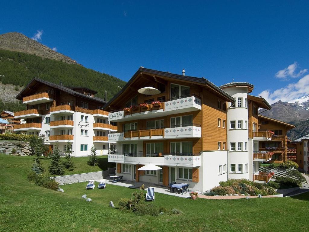 a large apartment building on a hill with a mountain at Dolce Vita in Saas-Fee