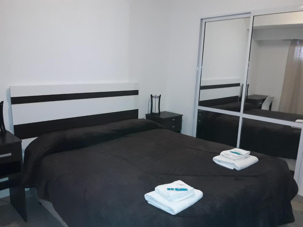 a bedroom with a bed with two towels on it at Apartamento céntrico 19 de Mayo con cochera in Bahía Blanca
