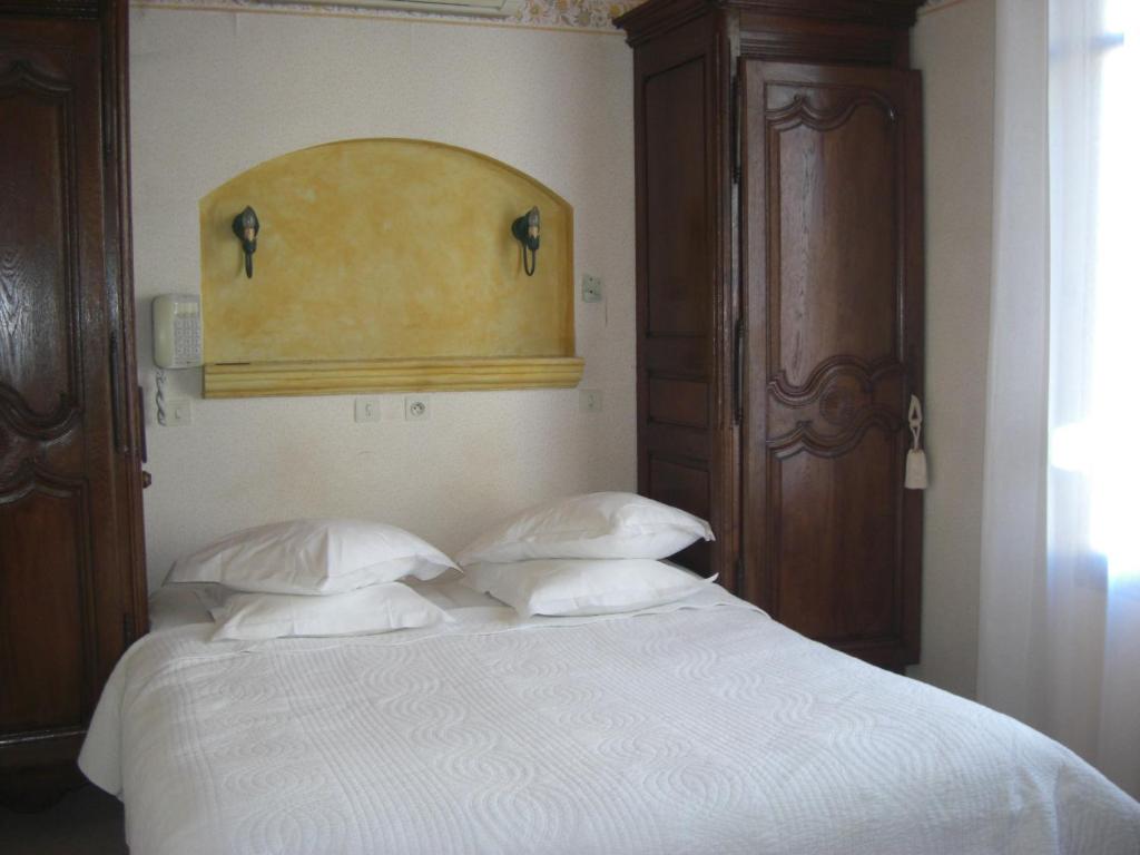 a bedroom with a white bed with two pillows at La Marjolaine in Juan-les-Pins
