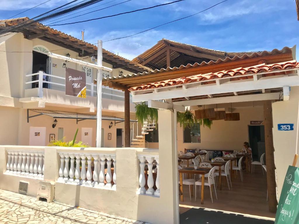 a house with a balcony and a table and chairs at Pousada Mel in Praia do Forte