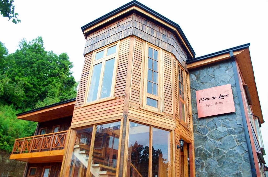 Cette grande maison en bois possède une grande fenêtre. dans l'établissement Apart Hotel Claro de Luna, à Frutillar