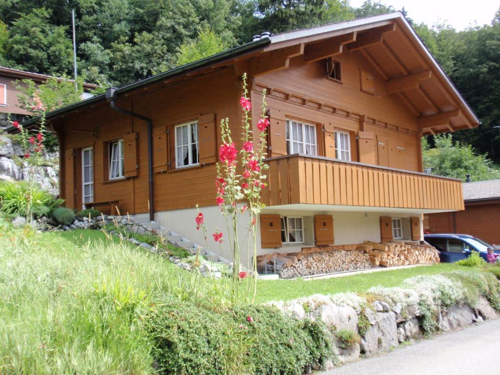 una casa de madera con flores delante en bella Romantica en Brunig