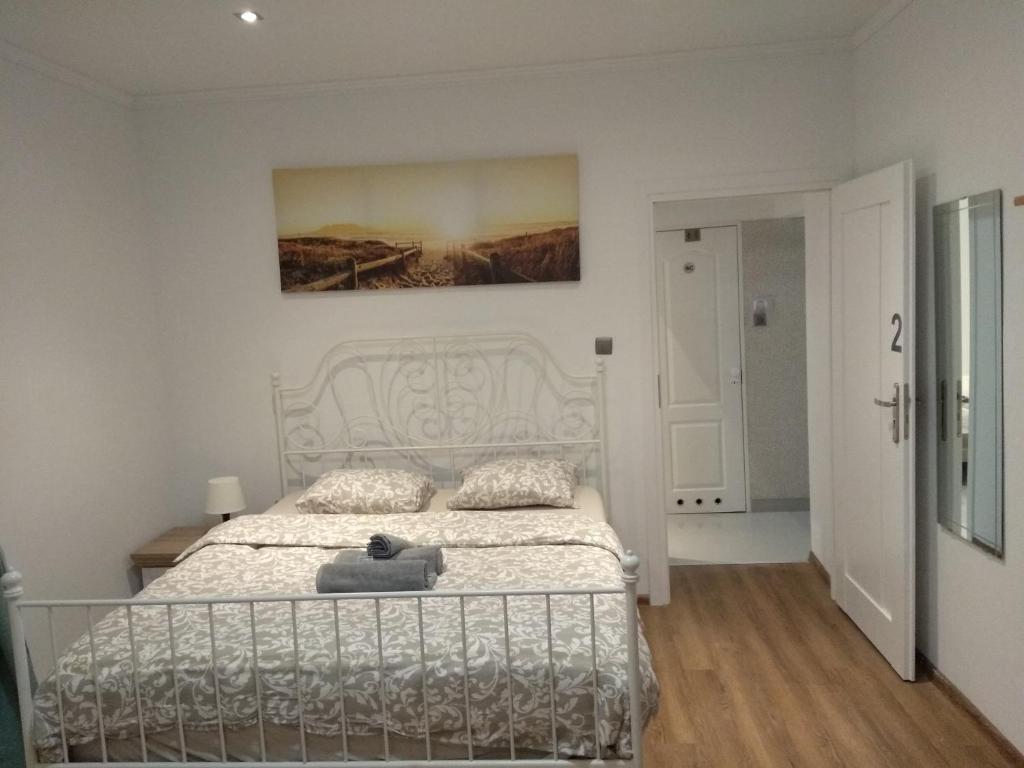 波茲南的住宿－Modern&Cozy Rooms，卧室配有白色的床和墙上的绘画作品