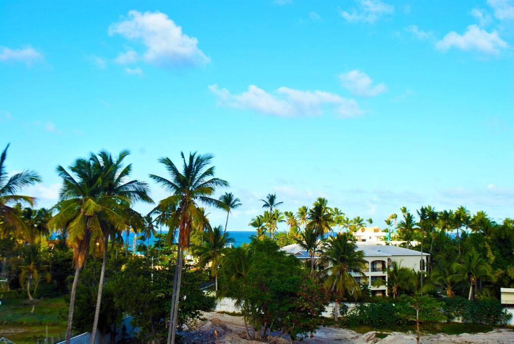 Blick auf ein Resort mit Palmen und das Meer in der Unterkunft Hostel Eco Punta Cana in Punta Cana