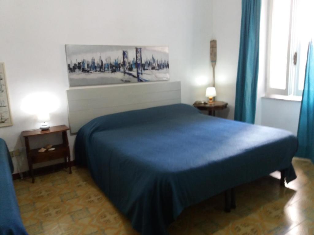 a bedroom with a blue bed and a painting on the wall at Bilocale Pascoli in Santa Teresa Gallura