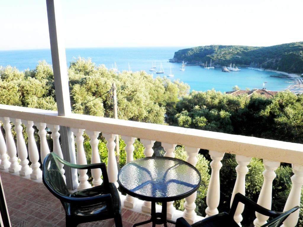 balcón con mesa, sillas y vistas al océano en Kanali Village Parga, en Parga