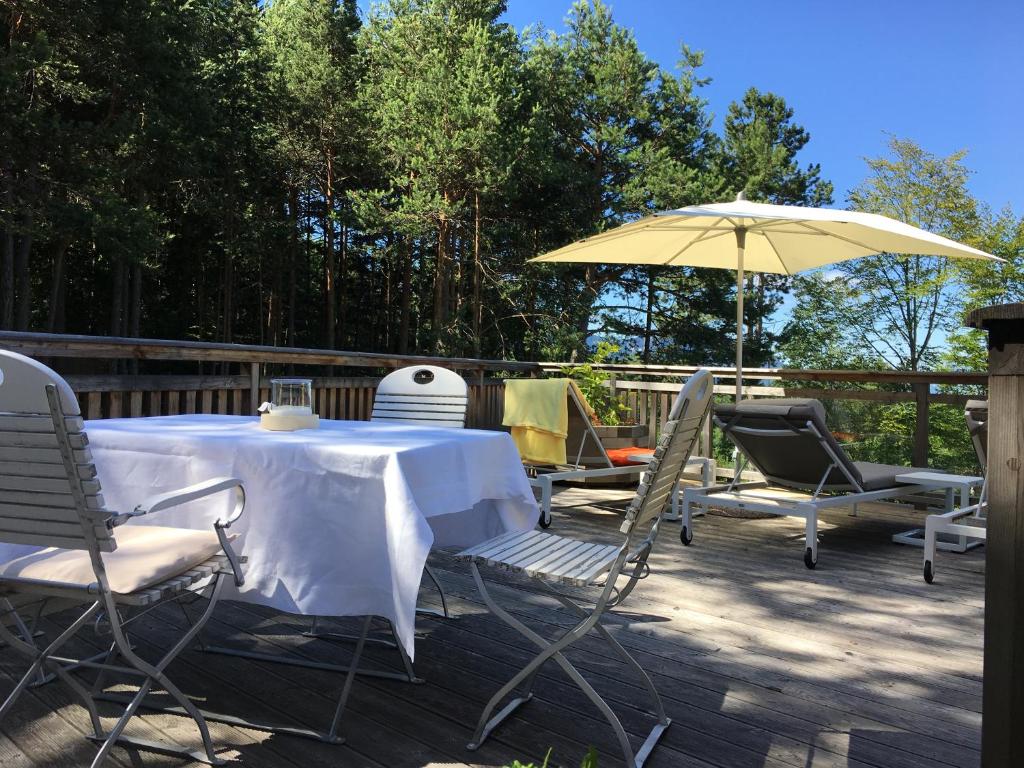 a table and chairs and an umbrella on a deck at Chalet Ly's Nest in Aldino