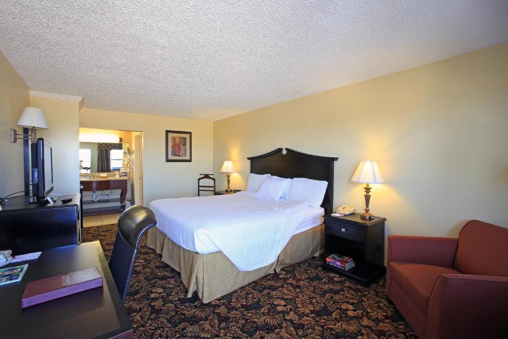 a hotel room with a bed and a couch at Plaza Inn Midland in Midland