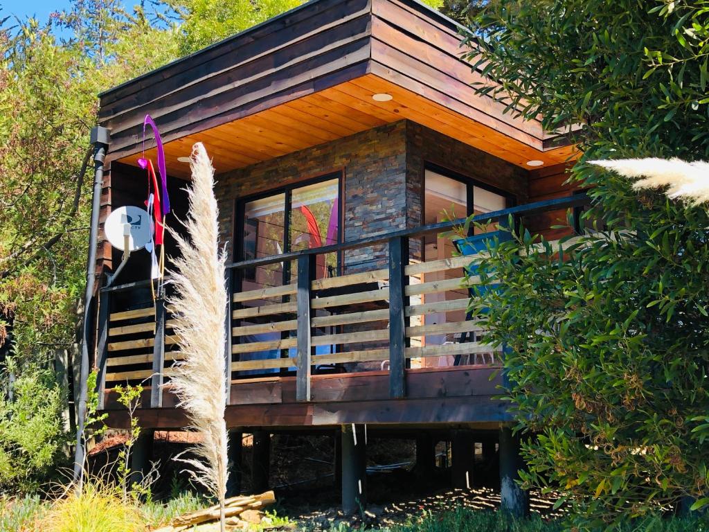 eine Hütte im Wald mit einer Veranda in der Unterkunft Cabaña del Bosque in Pichilemu