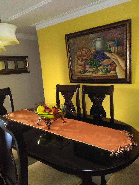a dining room table with a bowl of fruit on it at SANTIAGO CITY in Santiago de los Caballeros
