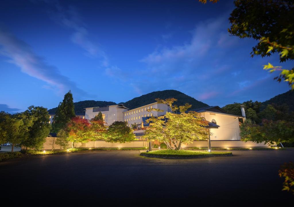 ein großes Gebäude mit einem Baum davor in der Unterkunft Iizaka Onsen Surikamitei Ohtori in Fukushima