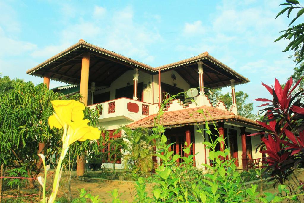 a house with a balcony on top of it at Sinhagiri Villa in Sigiriya