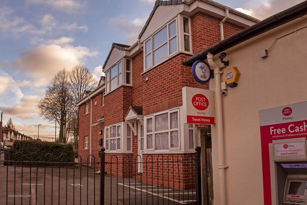 un edificio con un reloj al costado. en Birmingham Apartments Yardley B, BHX, NEC & City Centre, en Birmingham