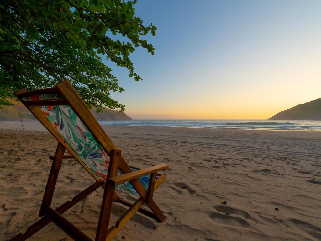 a beach chair sitting on a sandy beach at Pousada Canto Bravo in Ilhabela