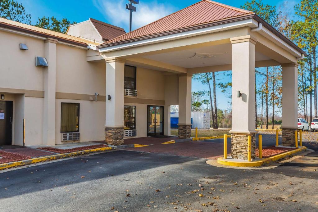 a building with a parking lot in front of it at Motel 6-Suwanee, GA - Gwinnett Center in Suwanee