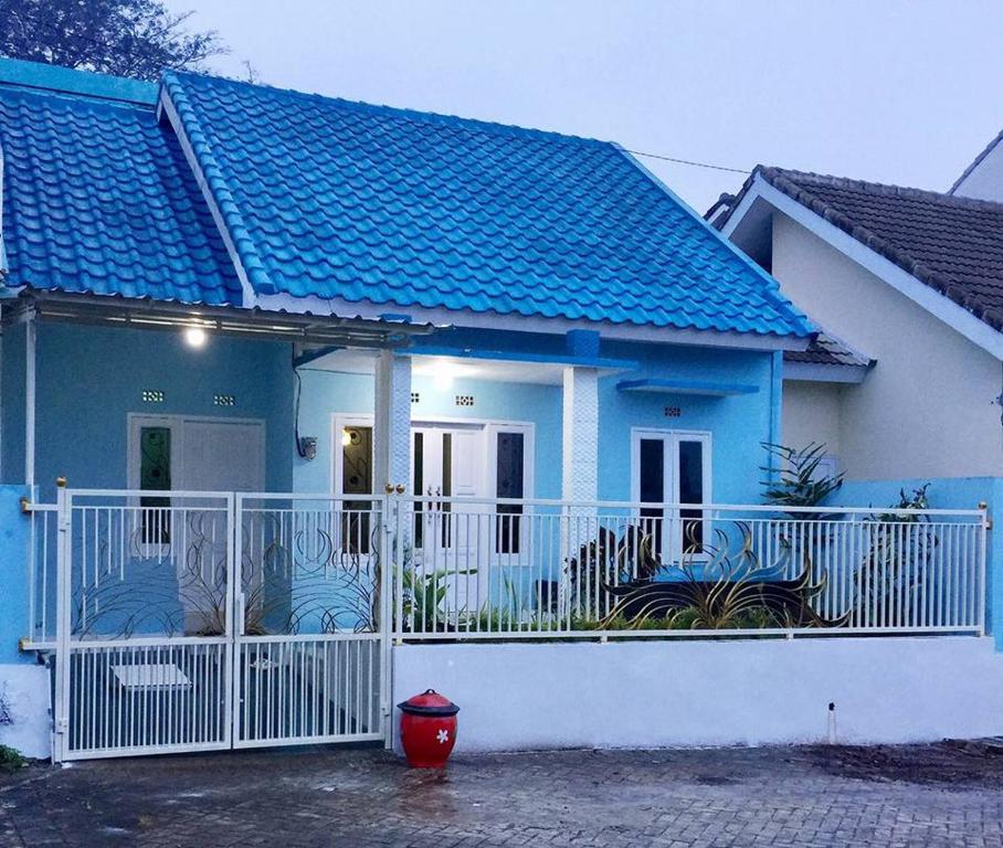 巴圖的住宿－Villa Aviation by Masterpiece Villa，前面有白色围栏的蓝色房子