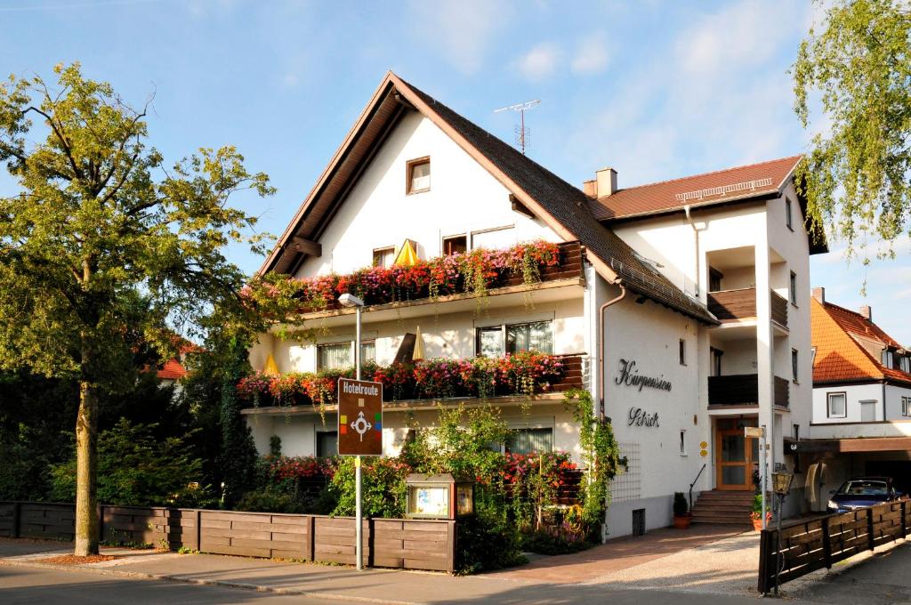 a white building with flowers on the side of it at Hotel Schick in Bad Wörishofen