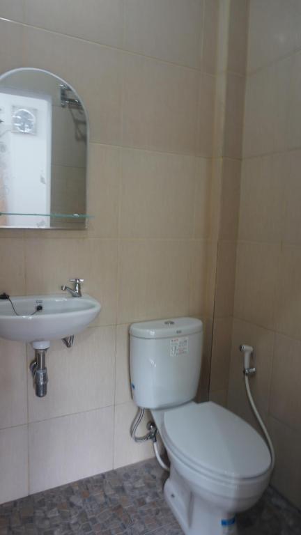 a bathroom with a white toilet and a sink at Al Barra Syariah Hotel in Bukittinggi