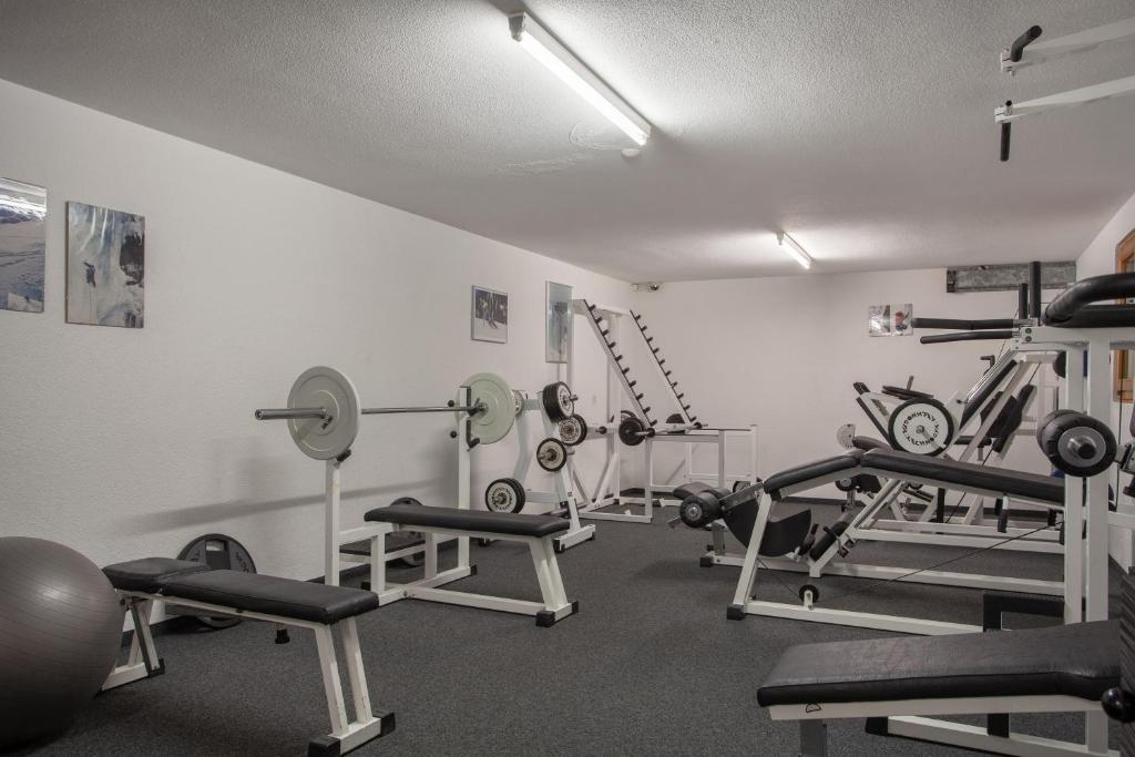 einen Fitnessraum mit Laufbändern und Gewichten in einem Zimmer in der Unterkunft Hotel Jägerhof in Zermatt
