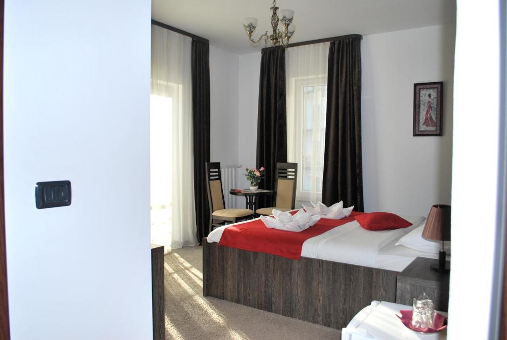 a hotel room with a bed with a red blanket at Harmonie Radauti in Rădăuţi