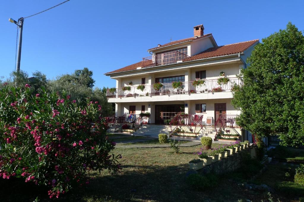 a large white house with a balcony and trees at Apartments Smolica in Labin