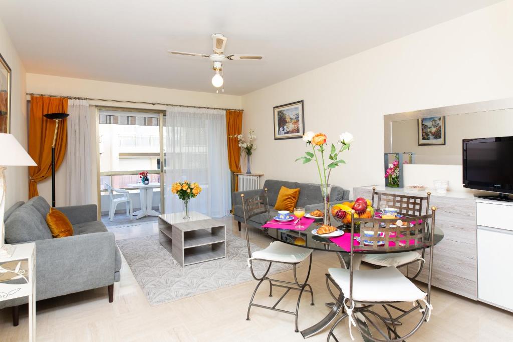 un salon avec une table et un canapé dans l'établissement Palais Royal YourHostHelper, à Cannes