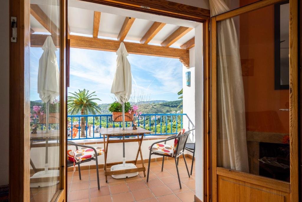 a room with a balcony with a table and chairs at Casa Herminia in Frigiliana